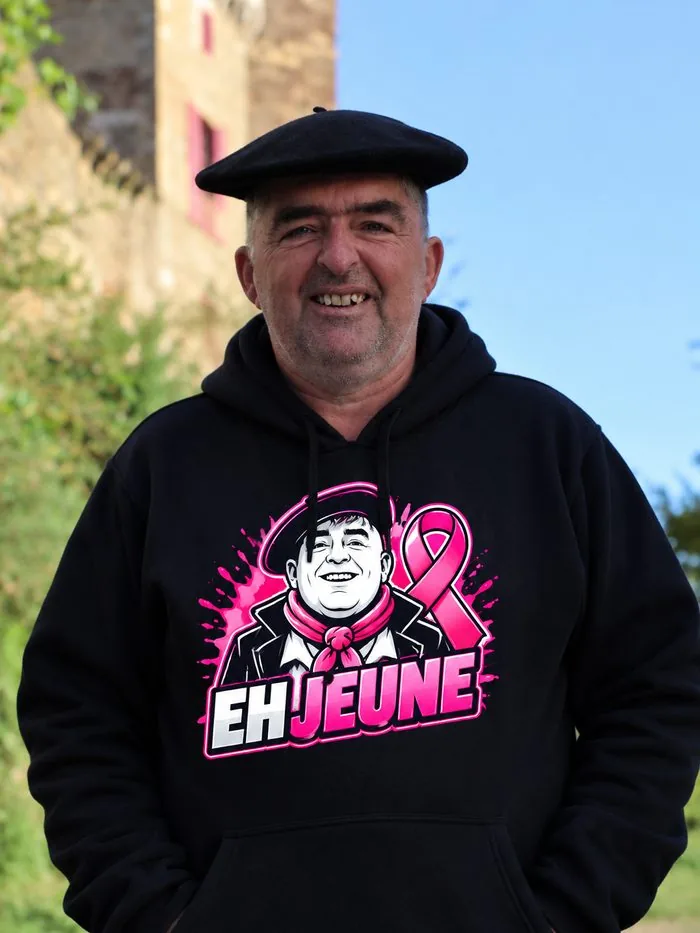 Pull noir EH JEUNE Octobre Rose, logo et ruban rose, porté par Frédéric Fraysse